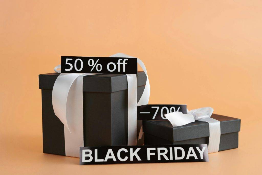 A black gift box against an orange background with Black Friday and 50% off text