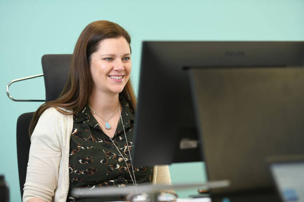 A female in an office working at a computer