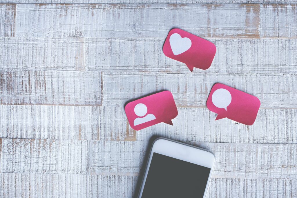 A phone on a white background with social media icons in speech bubbles