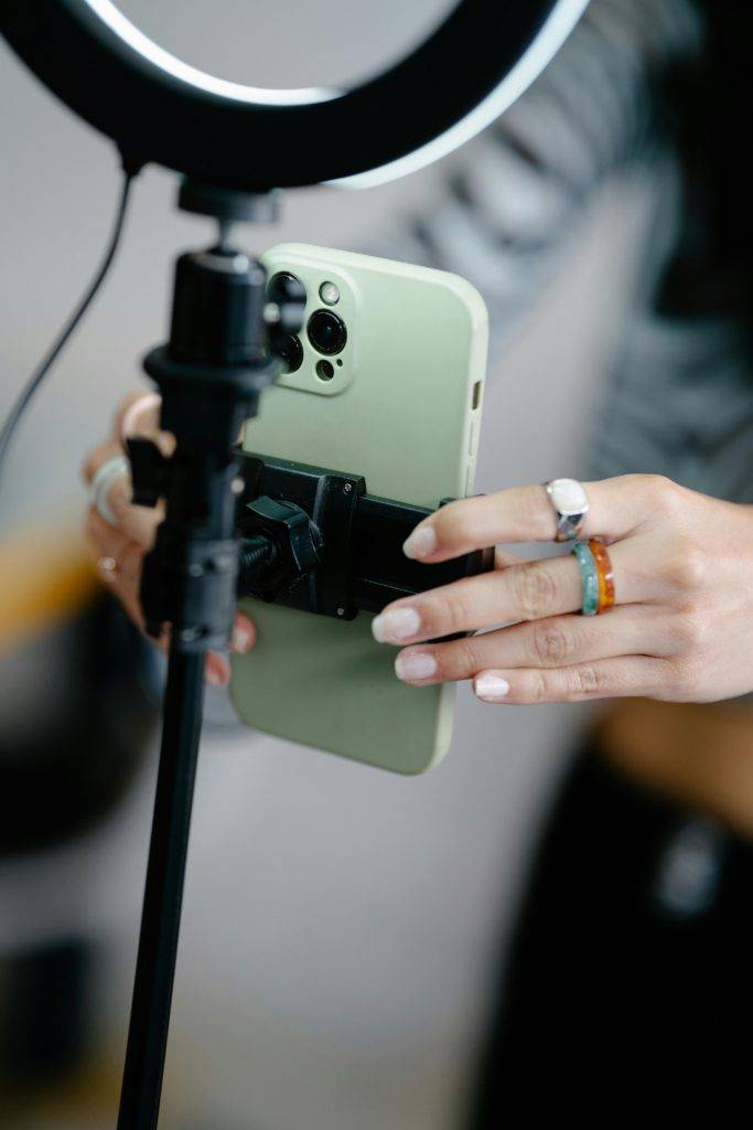 a smart phone being set up on a tripod with ring light