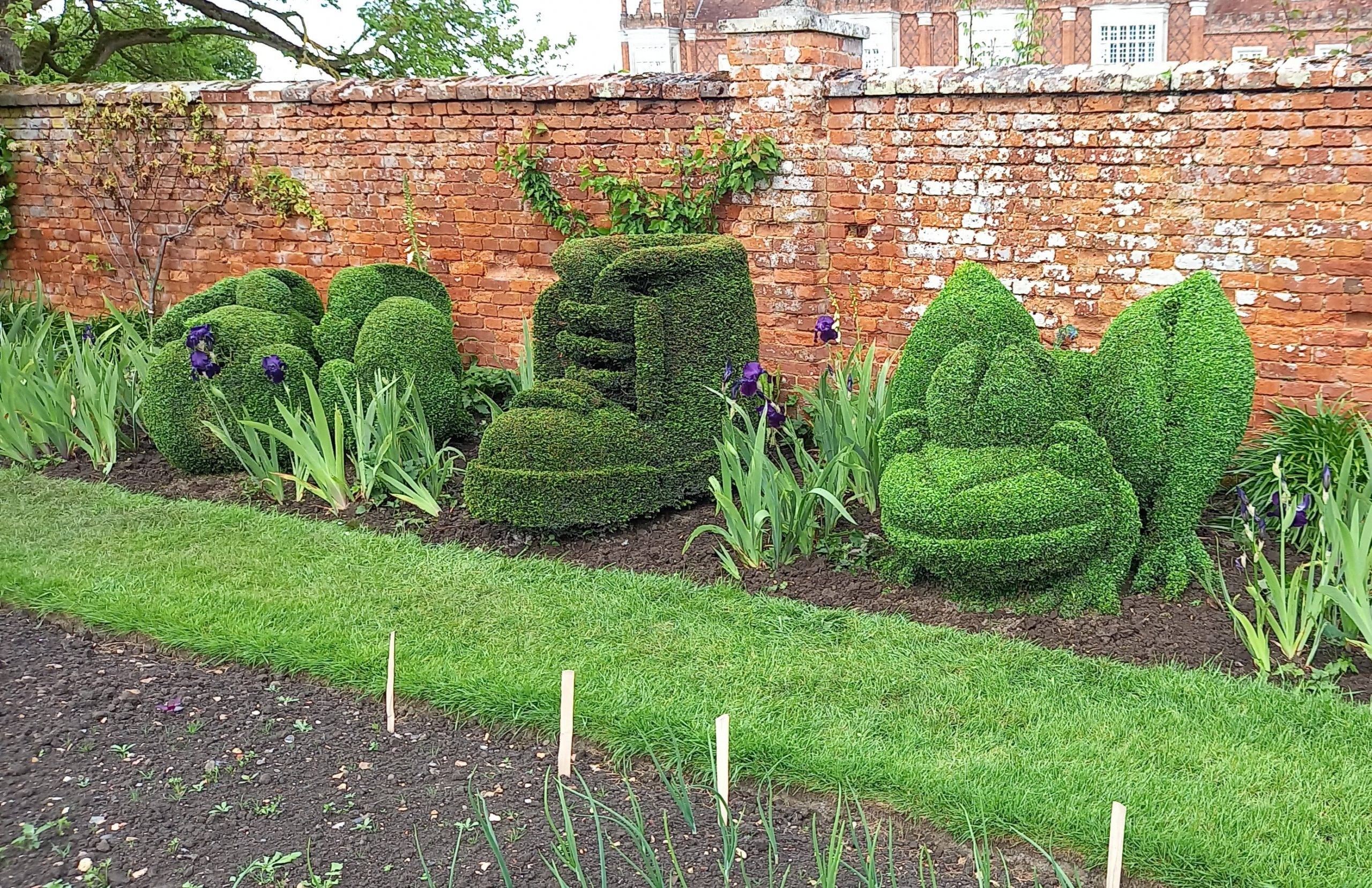 Topiary art of a boot and frog