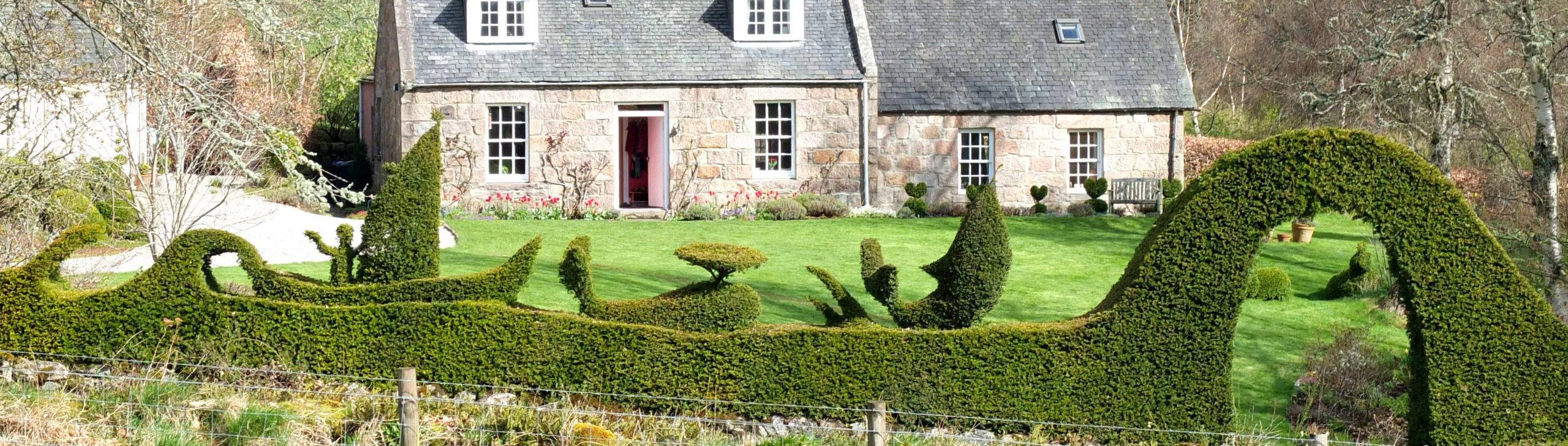 Topiary of a scene from moby dick and the arch as seen from the field