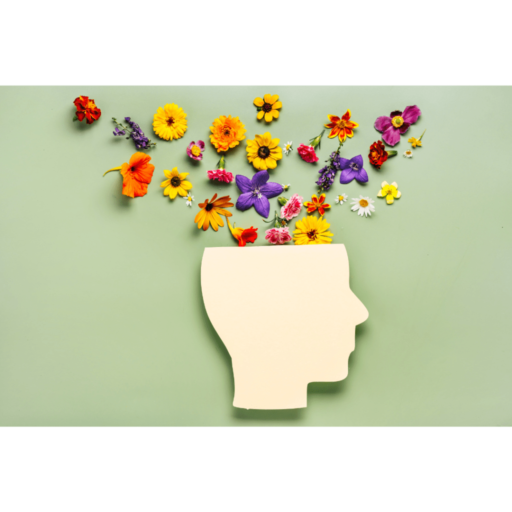 Mental health concept. Paper cut human head symbol and flowers on a green background.